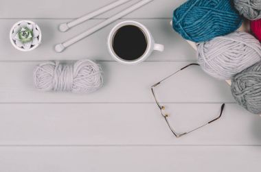 Örgü yün ve iğneler gri ahşap masa üzerinde arka plan