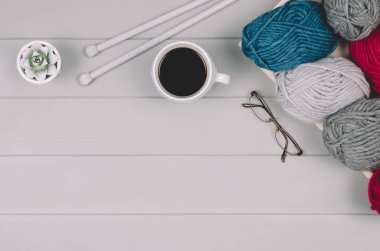 Örgü yün ve iğneler gri ahşap masa üzerinde arka plan