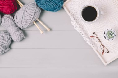 Örgü yün ve iğneler gri ahşap masa üzerinde arka plan