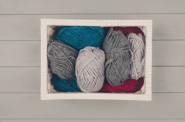 Knitting background with wool and needles on gray wooden table