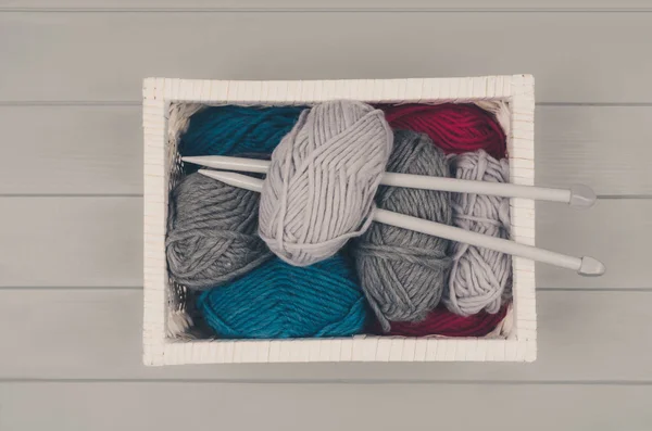 Stickning-bakgrund med ull och nålar på grå träbord — Stockfoto