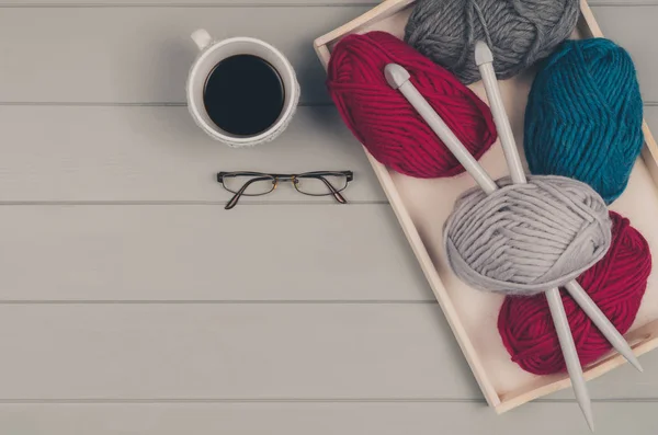 Fundo de tricô com lã e agulhas na mesa de madeira cinza — Fotografia de Stock