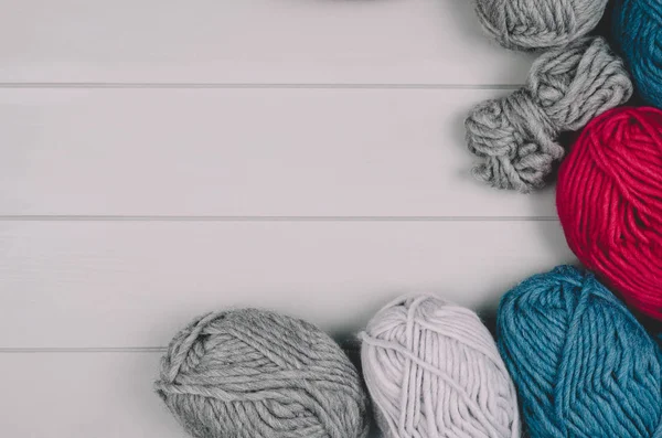 Fondo de punto con bolas de lana sobre mesa de madera gris — Foto de Stock