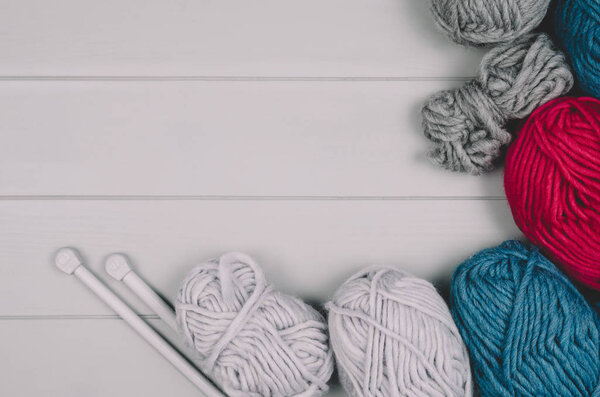 Вязание фона с шерстью и иголками на сером деревянном столе
