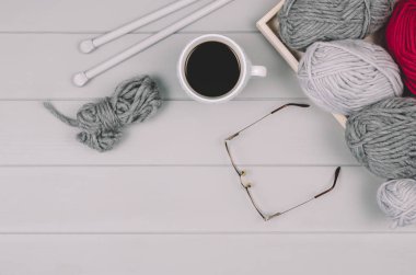 Örgü yün ve iğneler gri ahşap masa üzerinde arka plan