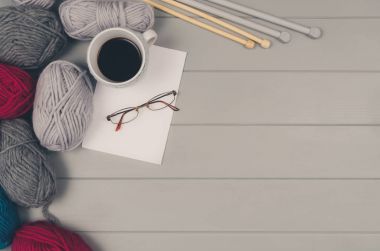 Örgü yün ve iğneler gri ahşap masa üzerinde arka plan