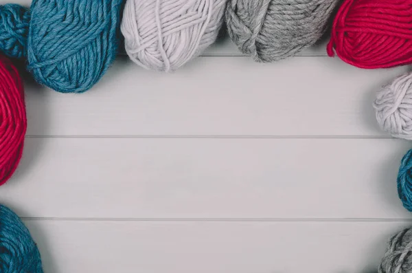 Fondo de punto con bolas de lana sobre mesa de madera gris — Foto de Stock