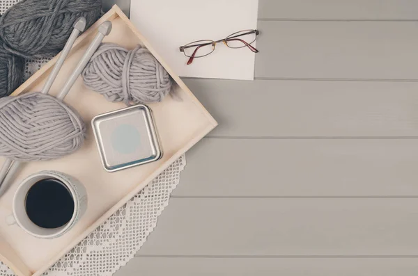 Sfondo a maglia con lana e aghi su tavolo grigio in legno — Foto Stock