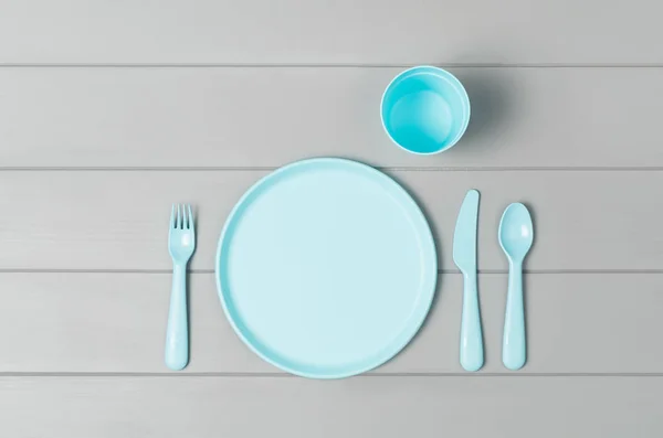 Crianças pastel utensílios de mesa de plástico isolado no fundo cinza. Vista superior — Fotografia de Stock