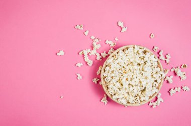 Patlamış mısır kase üzerinde pembe bir arka plan kopya alanı ile Üstten Görünüm