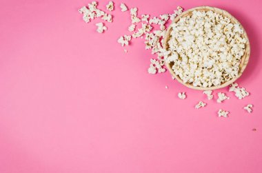 Patlamış mısır kase üzerinde pembe bir arka plan kopya alanı ile Üstten Görünüm