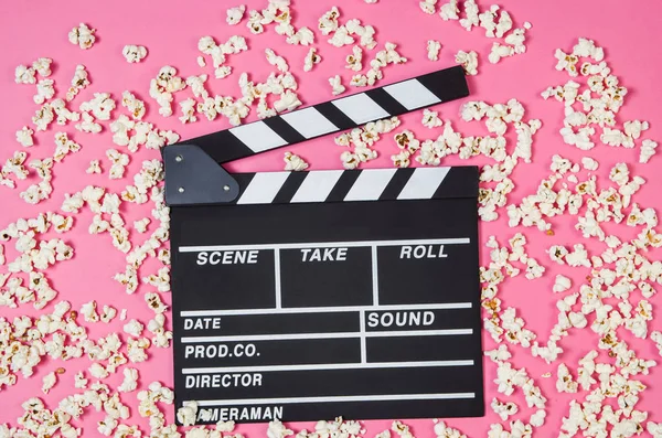 Popcorn, movie clip on pink background top view, copy space