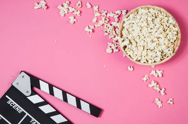 Popcorn, movie clip on pink background top view, copy space