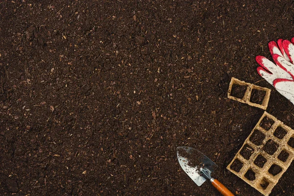 Trädgårdsredskap på jord textur bakgrund ovanifrån. — Stockfoto