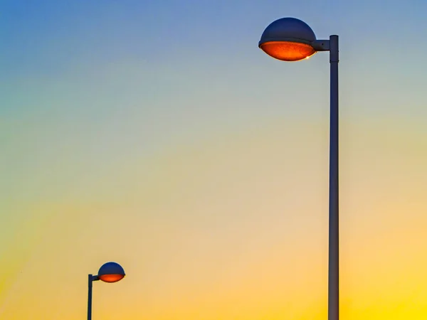 Sonnenuntergang über einer Stadt und Straßenlaternen — Stockfoto