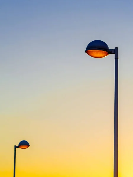 Pôr do sol em uma cidade e luzes de rua — Fotografia de Stock