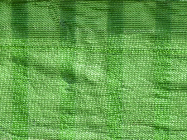 Textur aus grünem Textil auf einem Zaun — Stockfoto