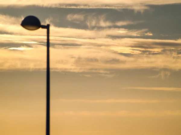 Luzes de rua no pôr do sol e paisagem urbana — Fotografia de Stock