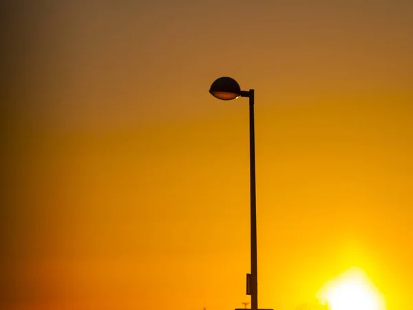 Straßenlaternen bei Sonnenuntergang und Stadtlandschaft — Stockfoto