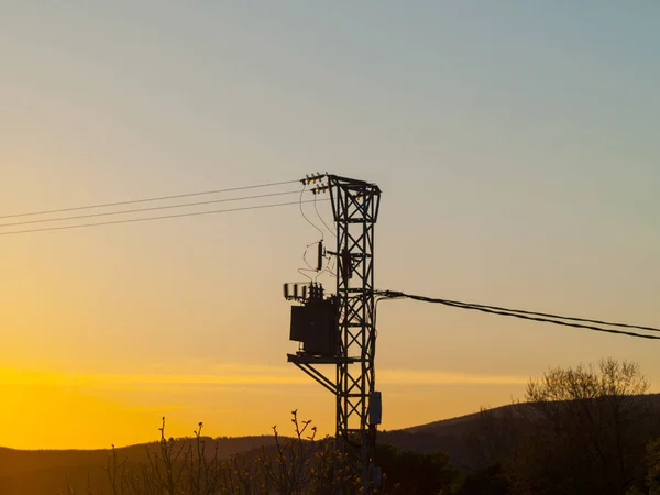 Torre de electricidad al atardecer en el campo con árboles en España — Foto de Stock