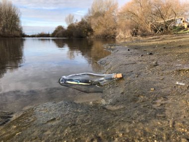 İleti bir kristal şişe su ve kum Beach