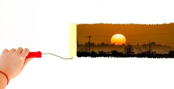 Una persona pintando un paisaje al atardecer en una pared blanca con un cepillo de rodillos — Foto de Stock