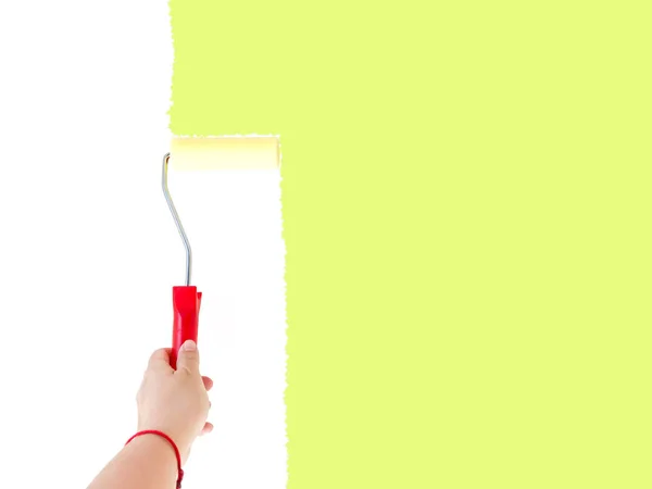 Una persona che dipinge una parete bianca con una spazzola a rullo — Foto Stock