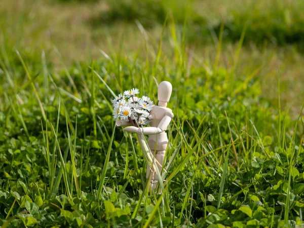 Manequim de madeira com um buquê de flores em seus braços na primavera Romantismo e conceito de amor — Fotografia de Stock