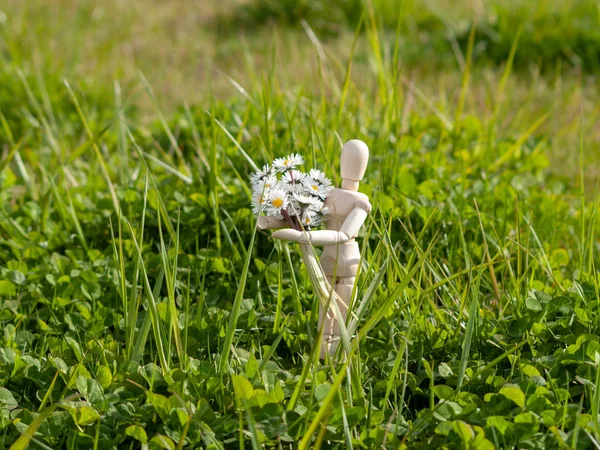 Manequim de madeira com um buquê de flores em seus braços na primavera Romantismo e conceito de amor — Fotografia de Stock