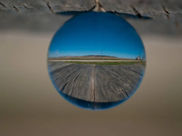Reflecties van heldere hemel in een kristallen bol op een houten tafel / concept van milieu — Stockfoto