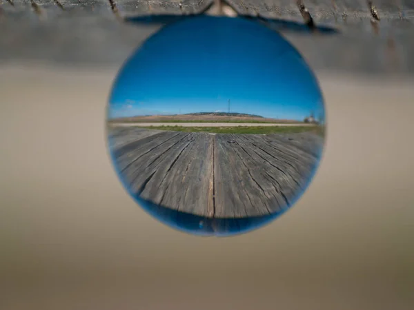 Reflexionen des klaren Himmels in einer Kristallkugel auf einem Holztisch / Konzept der Umwelt — Stockfoto