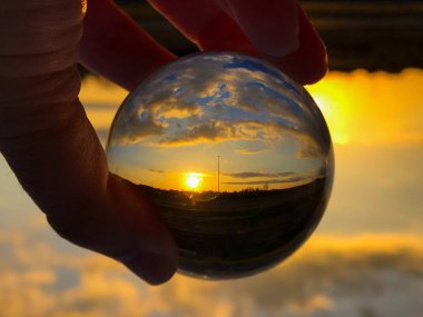 Reflections of the sunset in a cloudy day in a crystal ball / environment concept clipart