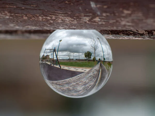 Reflexões de oscilações e deslizamentos em um parque em uma bola de cristal / conceito de infância — Fotografia de Stock