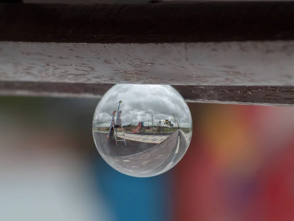 Houpačky a skluzavky v parku v křišťálové kouli / dětství koncepce — Stock fotografie