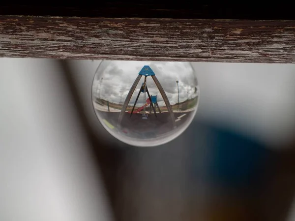 Reflexiones de columpios y toboganes en un parque en un concepto de bola de cristal / infancia — Foto de Stock