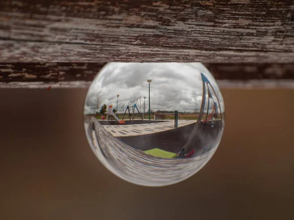 Reflexiones de columpios y toboganes en un parque en un concepto de bola de cristal / infancia — Foto de Stock