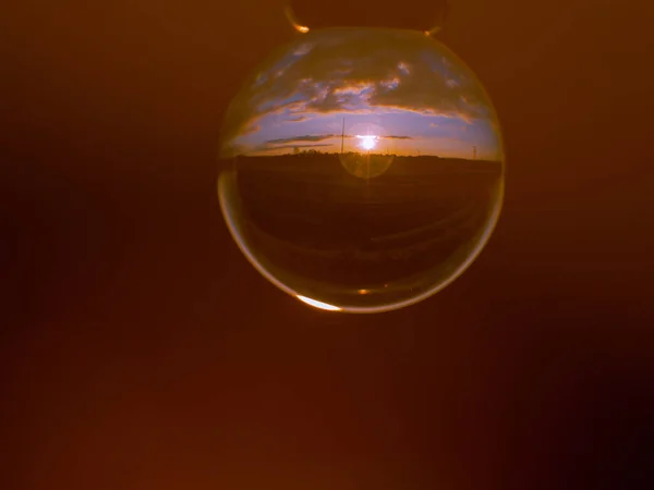 Reflections of the sunset in the city in a crystal ball / environment concept — Stock Photo, Image