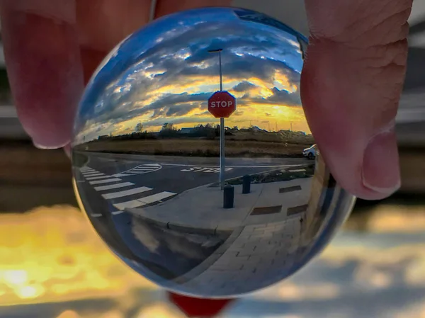 Reflexões de um sinal de parada e passarela ao pôr do sol em uma bola de cristal / conceito de tráfego — Fotografia de Stock