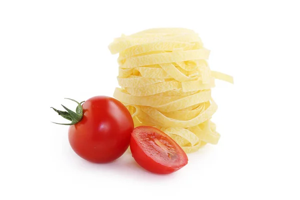 Итальянская паста и помидоры вишня на белом фоне — стоковое фото