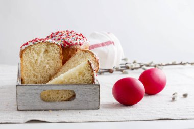 Paskalya pastaları, yumurtalar ve söğüt dalları bir masa örtüsü üzerinde.