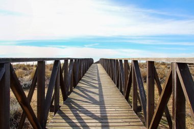 Ahşap geçit üzerinde plaj kum tepeleri. Andalusia, İspanya doğal bir alan içindeki Huelva Beach, plaj yolu