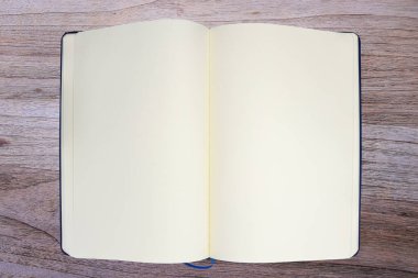 Ahşap arkaplan üzerindeki boş defter sayfasının üst görünümü