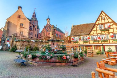 Eguisheim, Alsace, Fransa 'da Noel için süslenmiş eski bir çeşme.