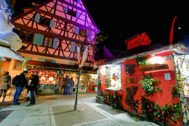 Colmar, Fransa - Aralık 1,2019: Fransa 'nın Alsace bölgesindeki Colmar şehrindeki geleneksel yarı keresteli evler arasında Noel Pazarı