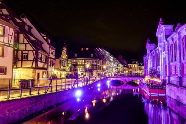 Geleneksel Alsaslı yarı keresteli evler ve Petite Venise 'deki Lauch nehri ya da eski Colmar kasabası, Fransa' nın Alsace şehrinde Noel zamanı dekore edilmiş ve aydınlatılmış.