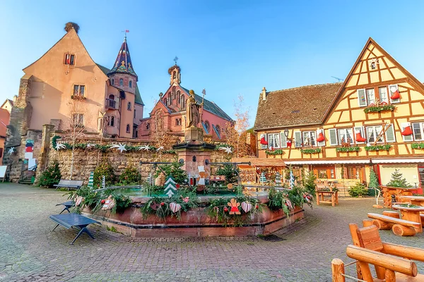 Eguisheim, Alsace, Fransa 'da Noel için süslenmiş eski bir çeşme.