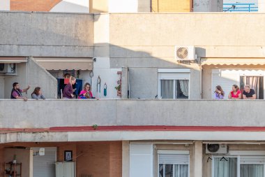 Huelva, İspanya - 5 Nisan 2020: Vatandaşlar her gün saat 8 'de ölümcül koronavirüs salgını sırasında alkış tutmak için balkonlara çıkıyorlar. İspanya 'da karantinadaki insanlar