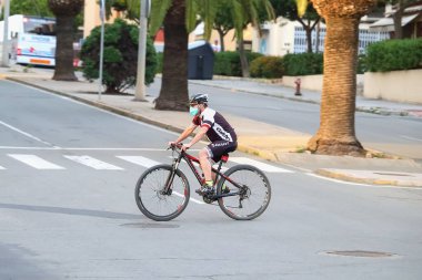 Huelva, İspanya - 7 Mayıs 2020: İspanya 'da alarm durumu ve karantina sırasında bir adam bisiklet sürüyor, burun ve ağız için koruyucu bir maske takıyor.