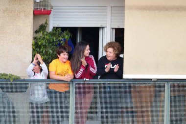 Huelva, İspanya - 15 Nisan 2020: Vatandaşlar ölümcül koronavirüs salgını sırasında her gün saat 8 'de evlerinde balkonlarda alkışlıyorlar. İspanya 'da karantinadaki insanlar