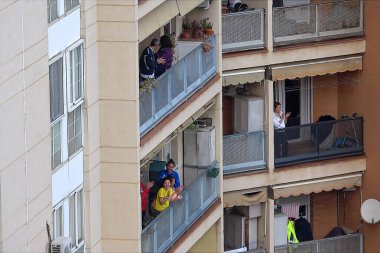 Huelva, İspanya - 9 Nisan 2020: Vatandaşlar ölümcül koronavirüs salgını sırasında her gün saat 8 'de evlerinde balkonlarda alkışlıyorlar. İspanya 'da karantinadaki insanlar